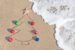 Christmas tree drawn in sand with real baubles