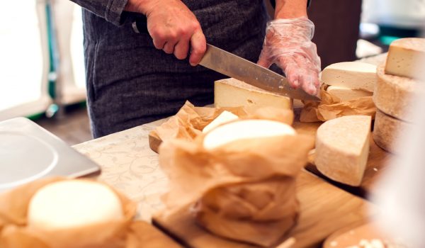 Seller prepares cheese for the customers